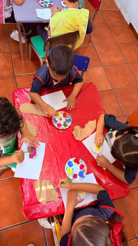 Niños creando y pintando juntos en el salón